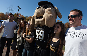 Members of the Bryant community pose with the mascot, Tupper, at Family and Friends Weekend