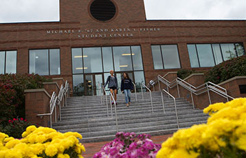 Students walk down the stairs at the Fisher Student Center at Bryant University