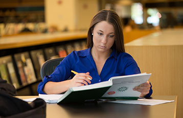 A student studies in the library at Bryant University