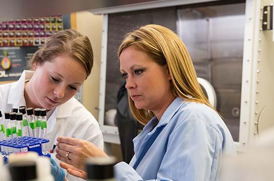 Bryant Professor Kirsten Hokeness works with an undergraduate student in a lab.