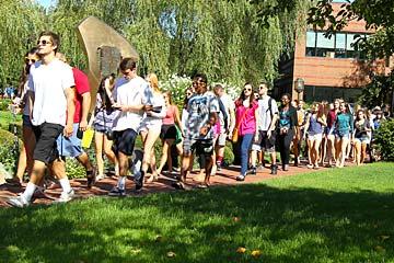 A stream of students walks the Bryant University campus during Orientation.