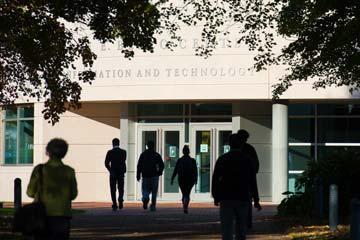 A group of Bryant students walk in front of the George E. Bello Center for Information and Technology.