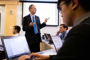 Bryant University Professor Peter Nigro instructs students inside a tiered classroom in the Unistructure.