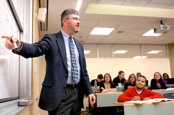 Bryant University Professor Chris Roethlein teaches in a classroom full of students.
