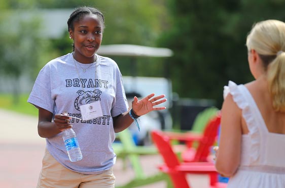 A Bryant University student speaks to a woman during Orientation.