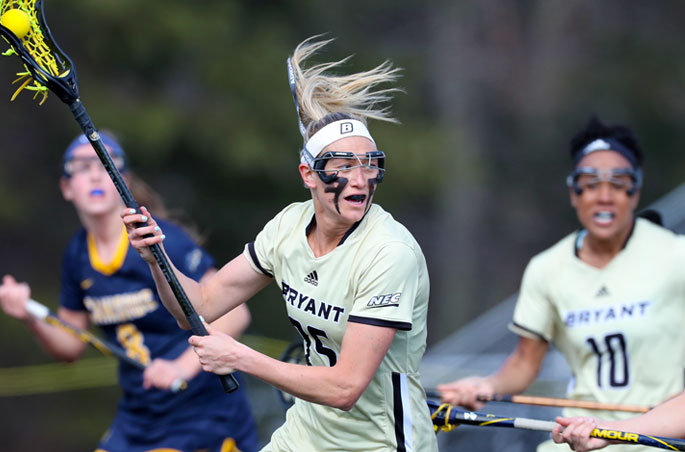 A Bryant women's lacrosse player handles the ball during a home game.