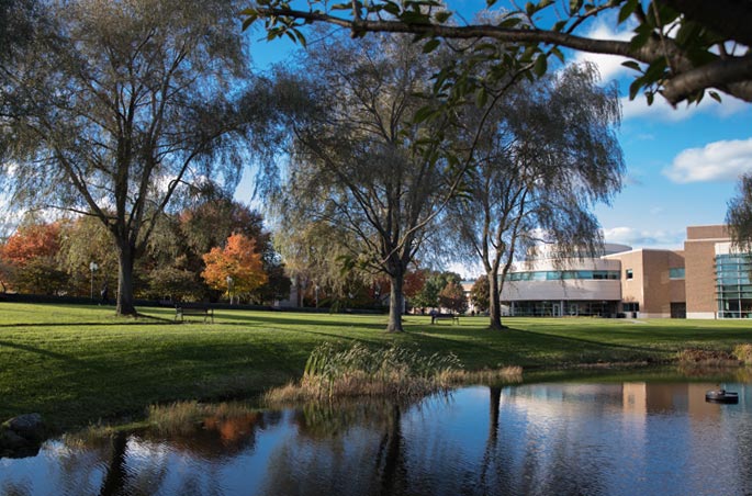 The pond, reflections and the George E. Bello Center for Information and Technology at Bryant University.