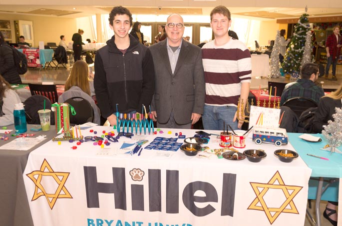 Three students promote the Hillel group at Bryant University.