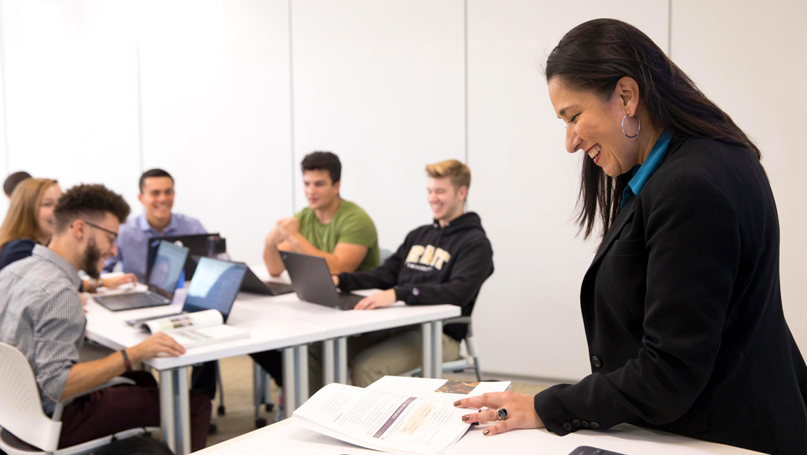 Bryant professor Patricia Gomez lectures in classroom in the Academic Innovation Center