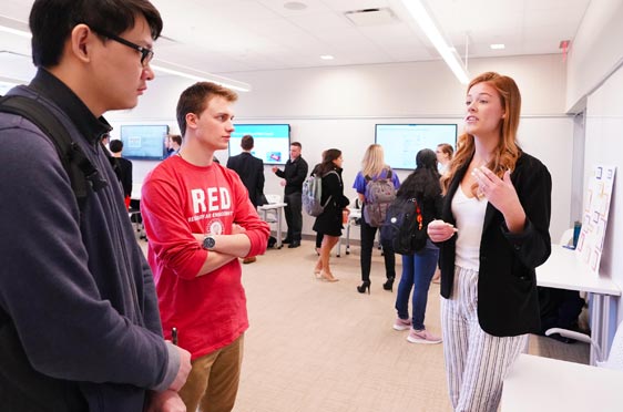 Two Bryant University students listen during a presentation at Research and Engagement Day.