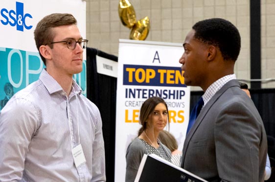 Student speaks with corporate recruiter at campus career fair