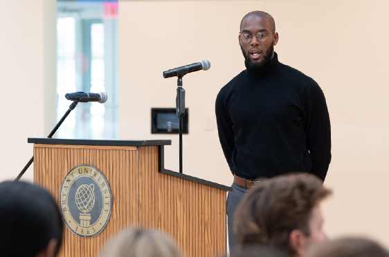 A Bryant student stands at a lectern during Research and Engagement Day.