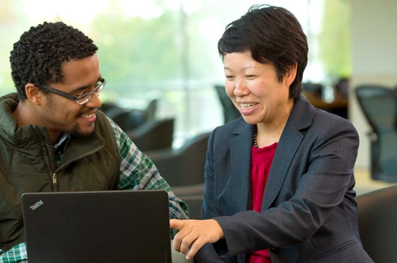 Professor Suhong Li works with a student.