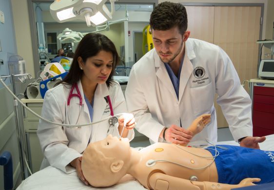 Students practice on a child manikin in the high-fidelity medical simulation center.