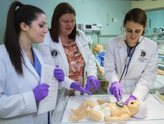 Students practice on an infant manikin in the high-fidelity medical simulation center.