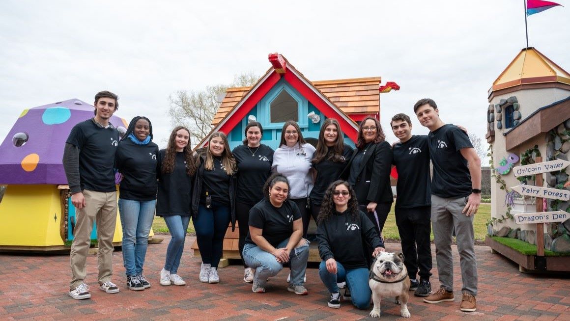 Bryant students pose in front of playhouses created as part of the Project Playhouse initiative. 