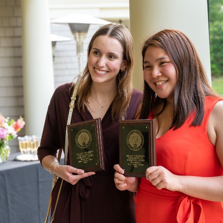 Two students pose at reception with communication awards