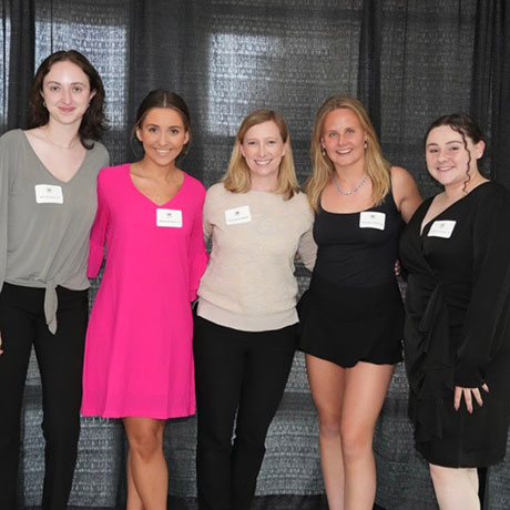 Samantha Mendez '24 poses with Professor Allison Butler and other Bryant students at an event.