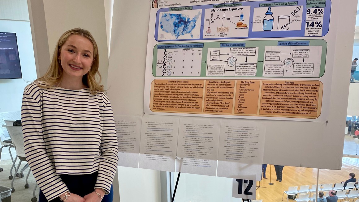 Student stands in front of nutrition research poster