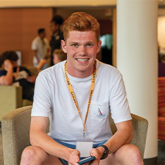 A Bryant University student poses in a chair.