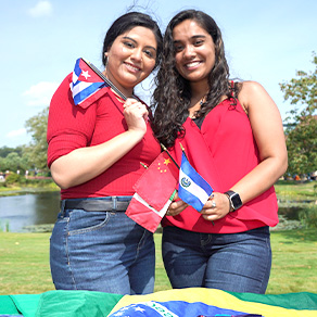 Two Bryant University students hold flags.