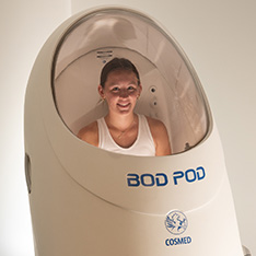 A Bryant student stands inside a Bod Pod within the Exercise and Movement Science Lab.