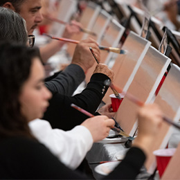 A group of people paint.